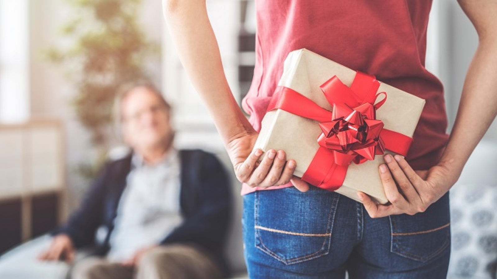 kobieta trzyma prezent za plecami